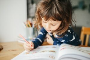 Menina estudando com livros didáticos
