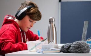 criança estudando com fones